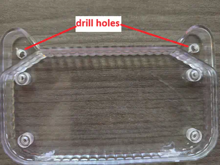 “drill holes” pointing to two spots in the cat ear portions of the front lens