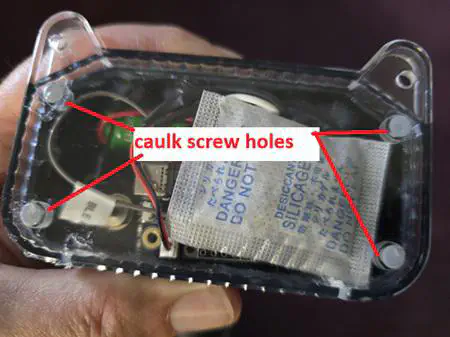 “caulk screw holes” pointing to the 4 holes in the front lens