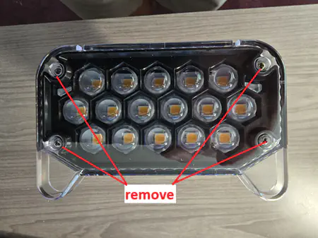 Annotated photo of the front panel, with red “Remove” arrows pointing to the 4 screw holes