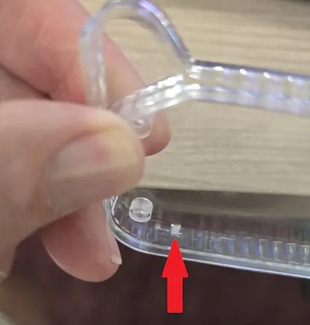 Arrow pointing to small hole on front lens
